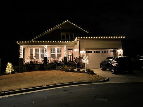 Warm white C9 roofline lights and wrapped porch columns on a craftsman bungalow in Cary, NC