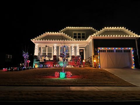 Warm white C9 roofline lights and multi-color accents on a craftsman home with a front porch in Cary, NC